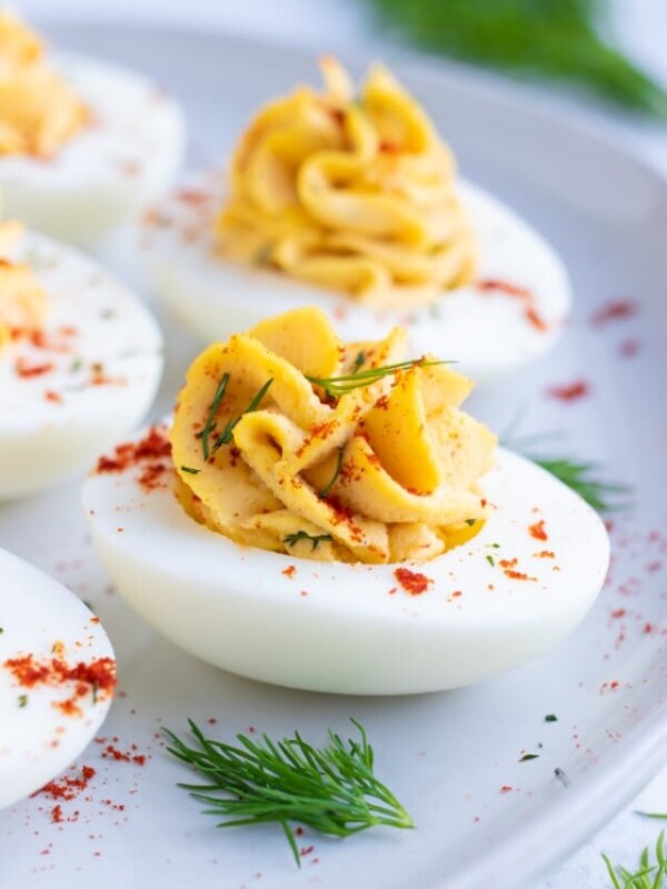 Low carb, keto, and Paleo deviled eggs made with mayonnaise and dill on a white plate.