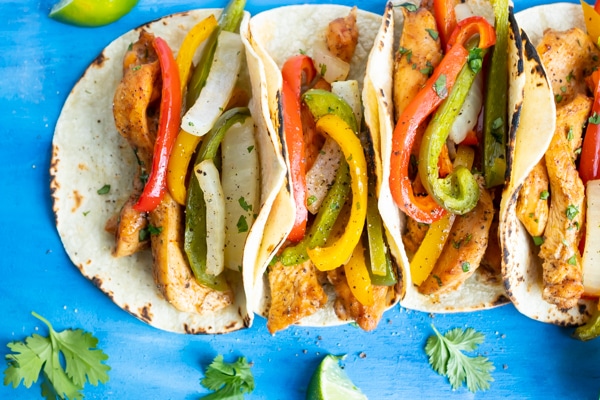 Oven fajitas with baked chicken and veggies in toasted corn tortillas.