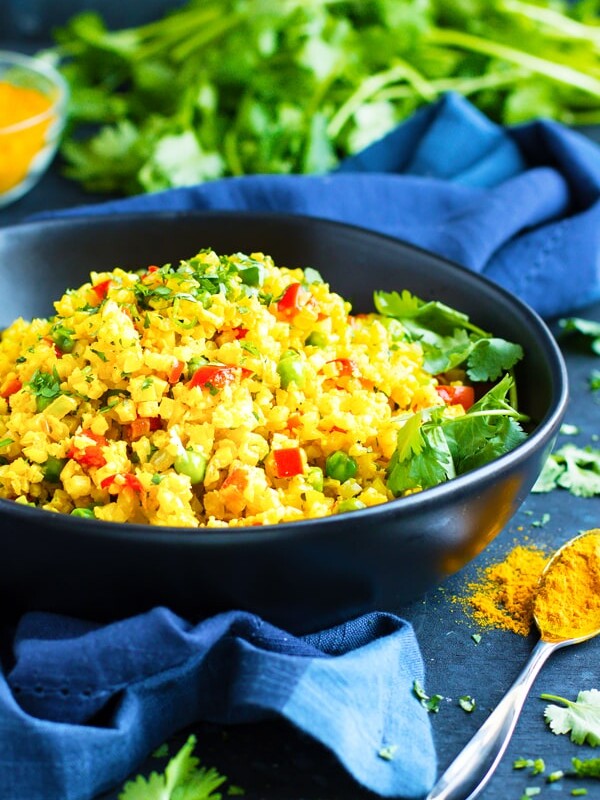 Easy Curry Cauliflower Rice in a bowl on a blue table.
