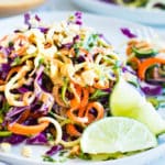 Easy zucchini noodle salad recipe on plate with limes for lunch.