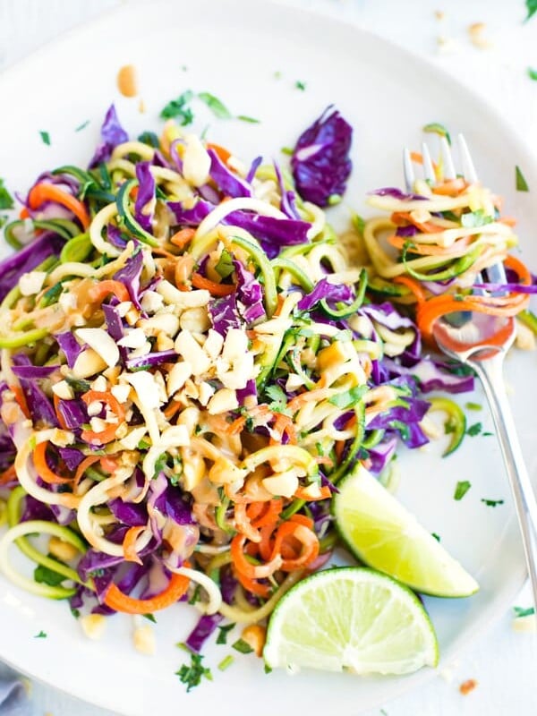 Gluten-free zucchini noodles on a white plate with a fork.