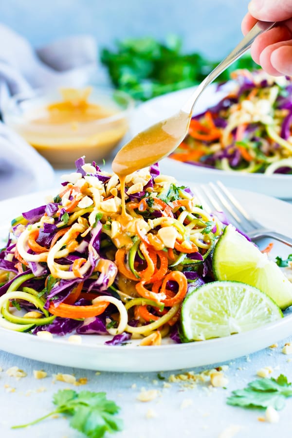 Gluten-free Thai Zucchini Noodle Salad with dressing drizzled on the top.