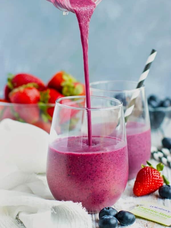 Berry beet smoothie being poured into a glass.