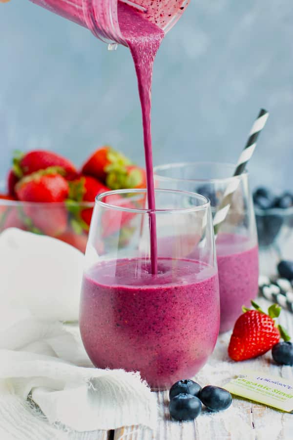 Berry beet smoothie being poured into a glass.