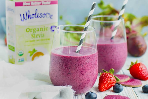 Beet banana smoothie in two glasses with Wholesome Organic Stevia in the background.