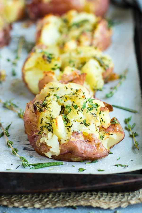 Gluten-free crispy smashed potatoes on a baking sheet lined with parchment paper.