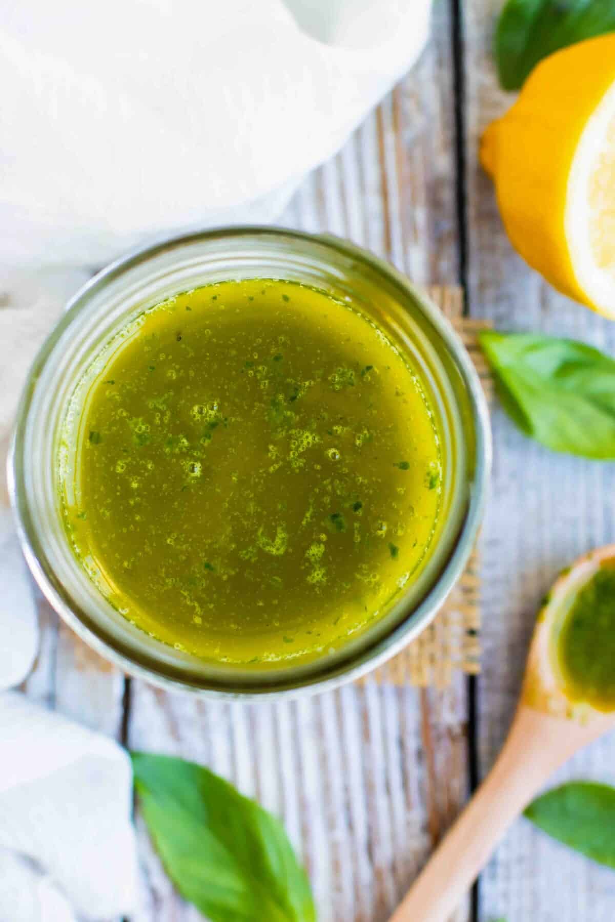 Easy vinaigrette dressing with basil and lemon in a glass jar.