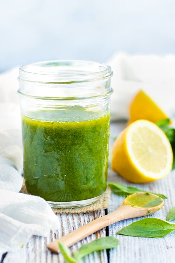 Gluten-free lemon vinaigrette recipe in a glass jar with a wooden spoon.