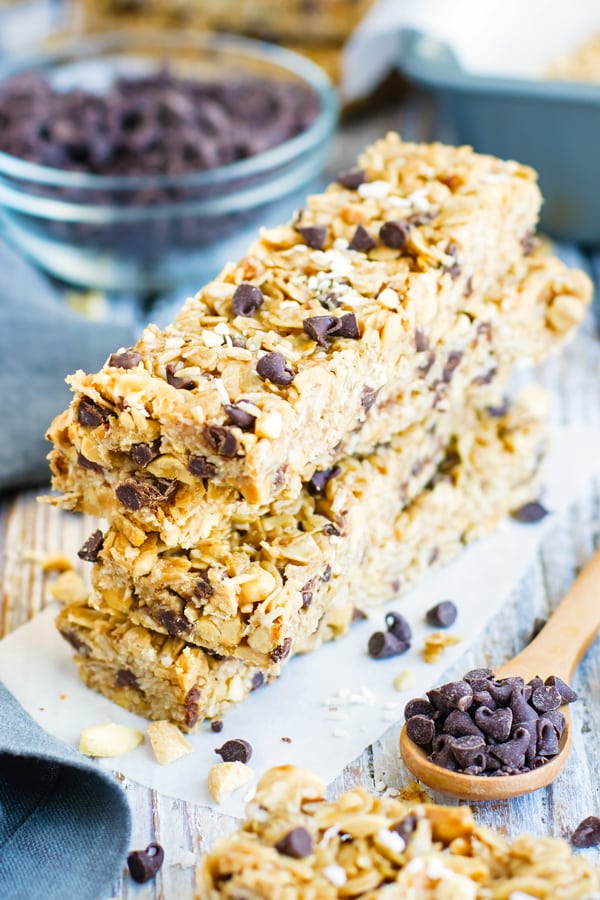 Peanut butter granola bars recipe on a piece of parchment paper with chocolate chips.