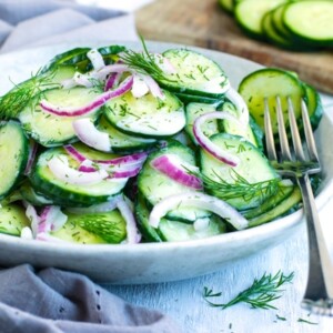 Delicious cucumber dill salad in a bowl with a fork on the side.