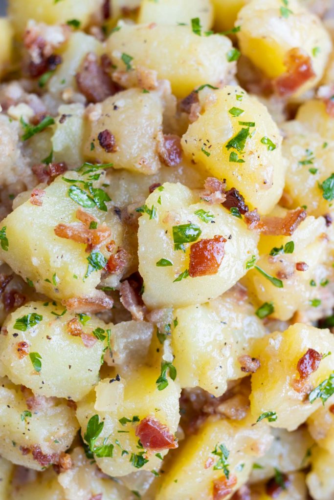 German potato salad is topped with fresh parsley before serving.