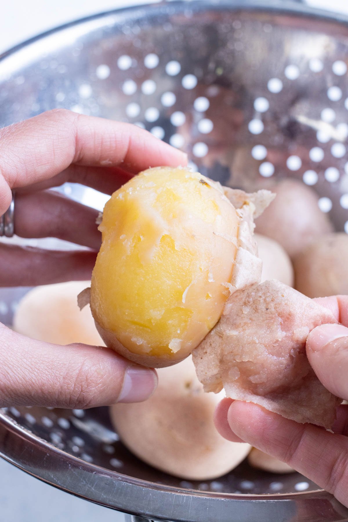 Skin is peeled from potatoes by hand.