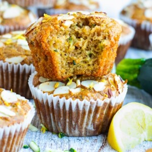 A picture of easy zucchini muffins with a whole zucchini on the side.