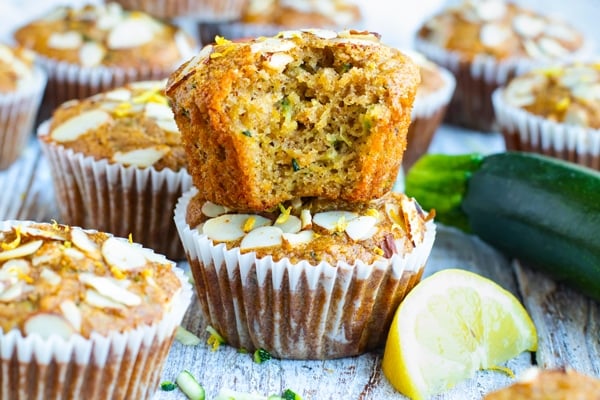 A picture of easy zucchini muffins with a whole zucchini on the side.