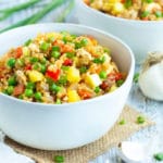 A white bowl of gluten-free cauliflower fried rice with pineapples.