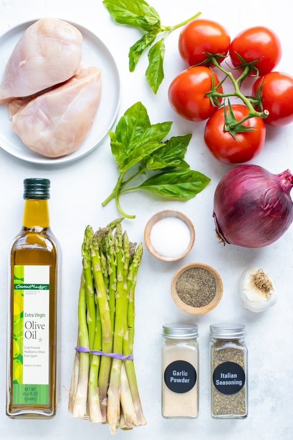 Chicken breasts, vine-ripened tomatoes, basil, asparagus, olive oil, and Italian seasoning as ingredients for a recipe.