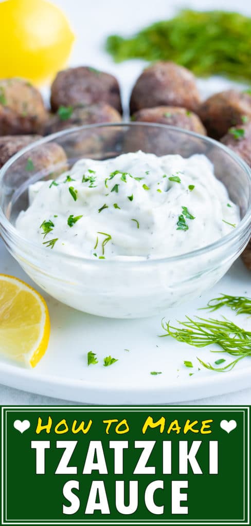 Creamy, authentic Greek tzatziki sauce full of fresh dill and Greek yogurt is placed in a glass bowl for dipping Greek meatballs.