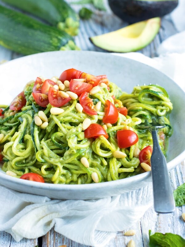 Beautiful picture of zucchini noodles and tomatoes on a table.