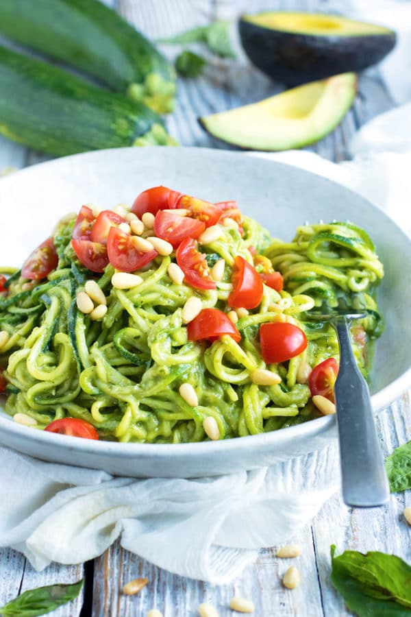 Beautiful picture of zucchini noodles and tomatoes on a table.