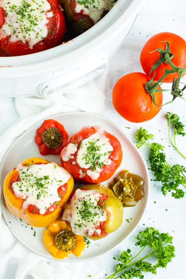Crock Pot stuffed peppers are loaded with lean ground turkey, cooked rice, and then topped with a flavorful tomato sauce for an easy and healthy weeknight dinner recipe.  Making this gluten-free stuffed bell peppers recipe in the slow cooker also makes clean-up a breeze!