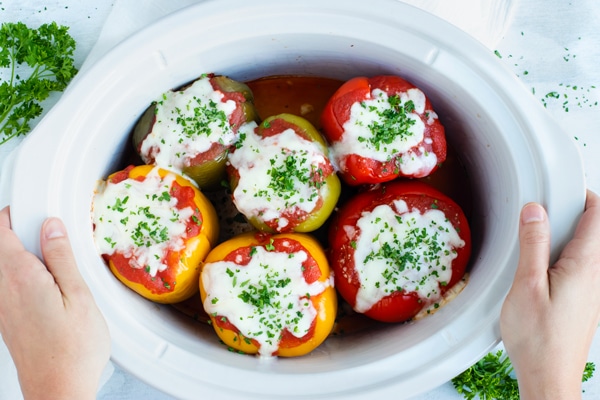 Crock Pot stuffed peppers are loaded with lean ground turkey, cooked rice, and then topped with a flavorful tomato sauce for an easy and healthy weeknight dinner recipe.  Making this gluten-free stuffed bell peppers recipe in the slow cooker also makes clean-up a breeze!