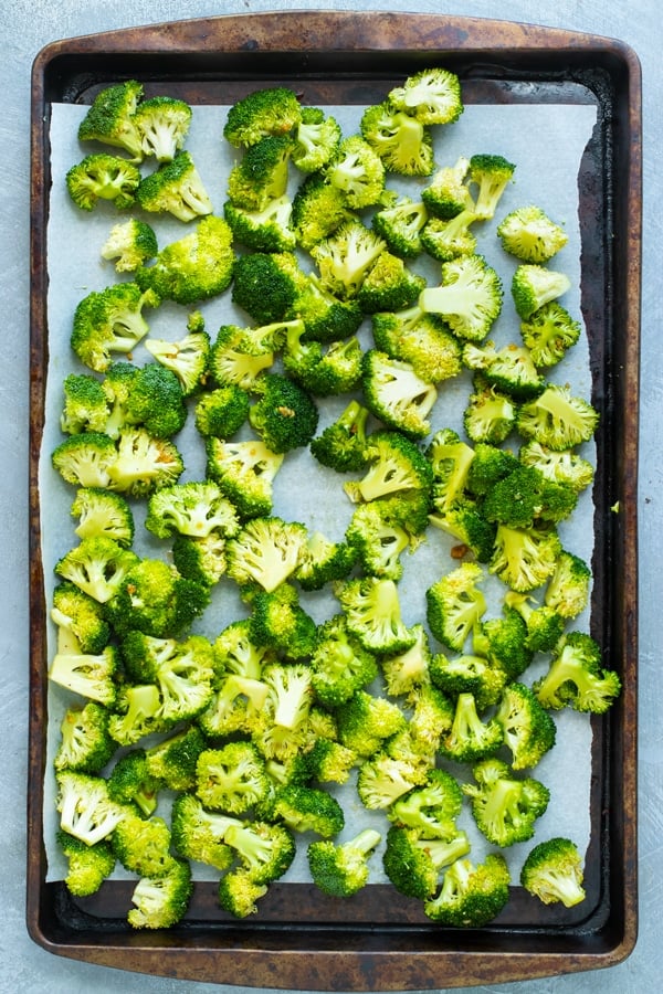 Honey oven roasted broccoli on a baking sheet with parchment paper.