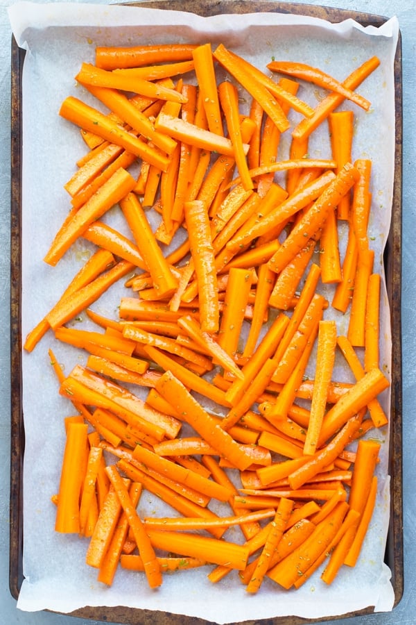 Honey roasted carrots on a baking sheet lined with parchment paper.