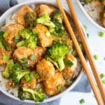 Easy sesame chicken recipe in a white bowl with chopsticks on the side.