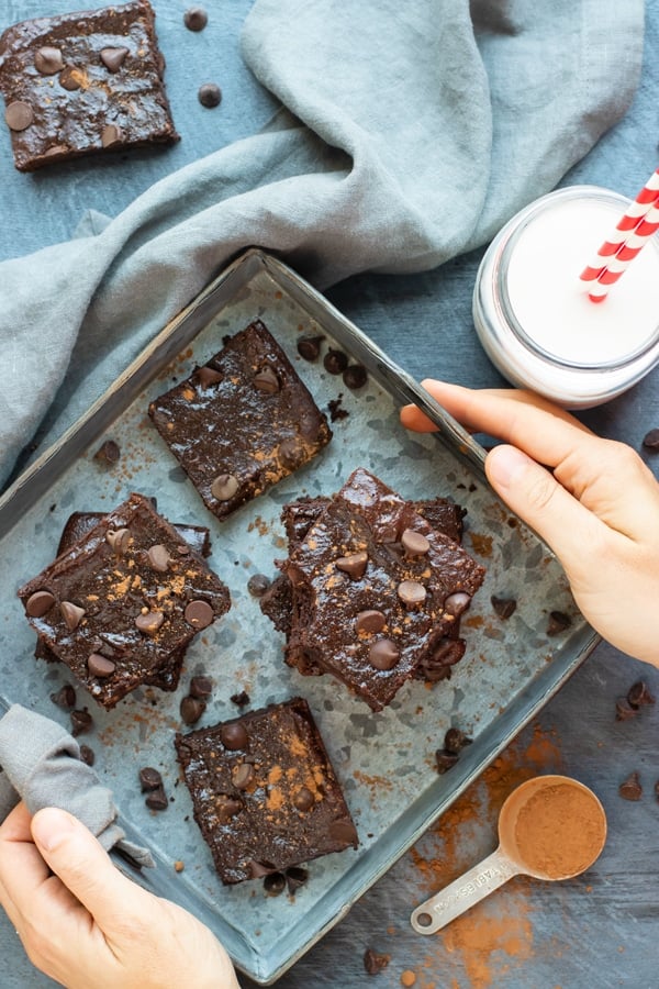 Paleo brownies in a square baking tray lined with parchment paper.