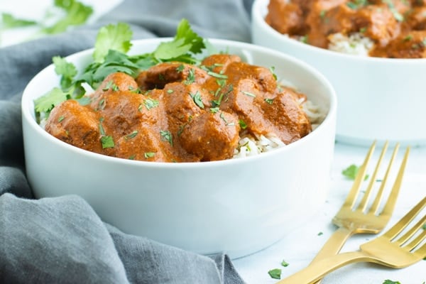 Crockpot Chicken Tikka Masala in a white bowl next to a gray napkin.