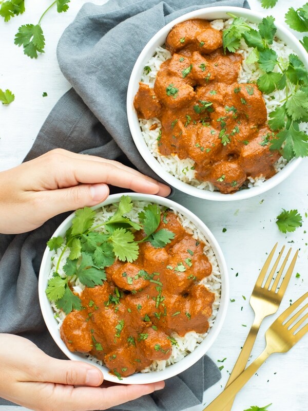 Two white bowls of gluten-free Slow Cooker Chicken Tikka Masala with forks on the side.