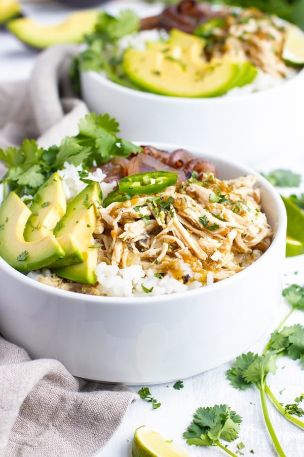 White bowl filled with Slow Cooker Shredded Chicken Burritos on a white table.