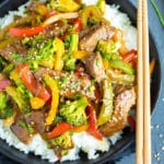 Healthy and easy beef and broccoli stir fry in a black bowl with chopsticks.