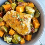 Oven Baked Chicken Thighs in a bowl surrounded by vegetables.