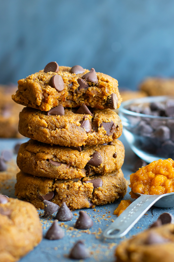 Healthy pumpkin cookies in a stack with a bite taken out.