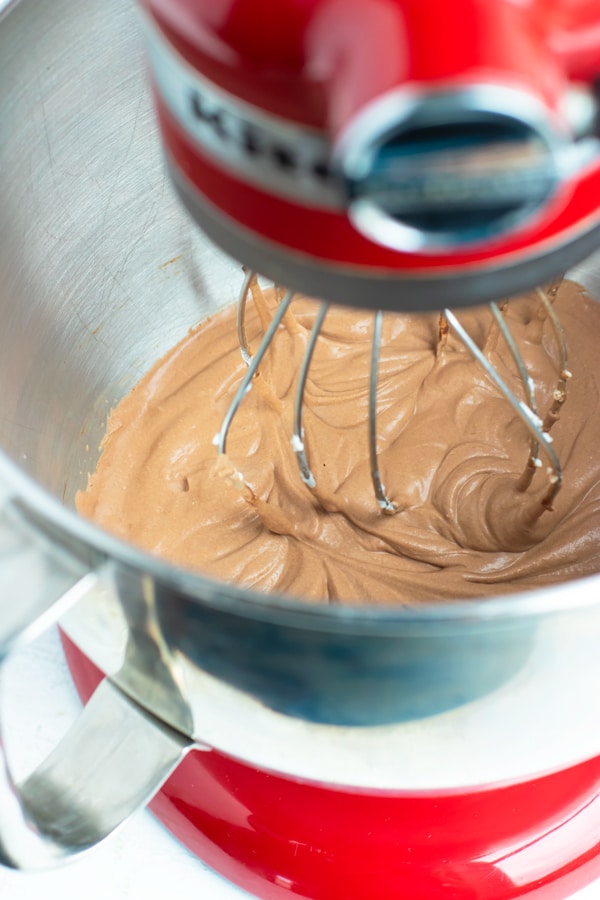 Demonstrating how to make chocolate mousse in a red Kitchenaid stand mixer with a metal whip attachment.