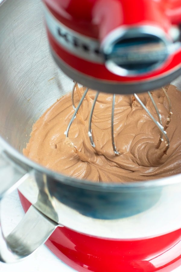 Demonstrating how to make chocolate mousse in a red Kitchenaid stand mixer with a metal whip attachment.