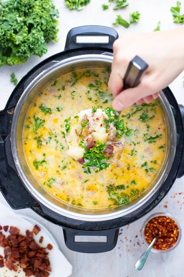 Zuppa toscana soup being scooped out of an Instant Pot.