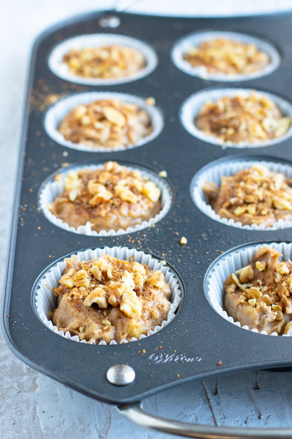 A muffin tray full of healthy banana bread muffin batter.