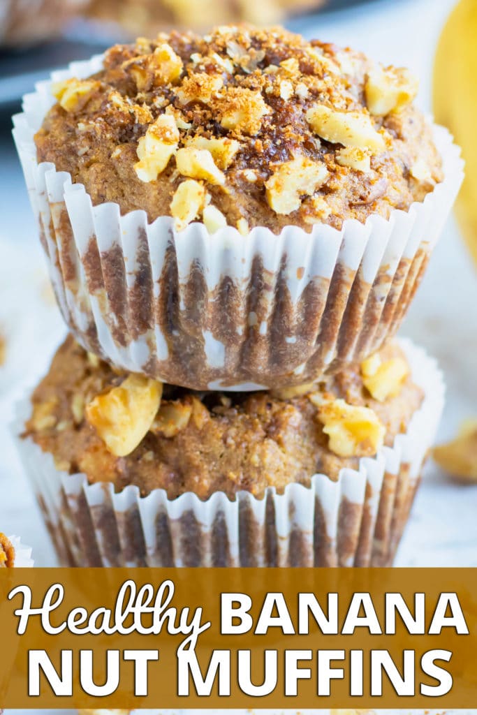 Two healthy banana muffins in a stack with other gluten-free and Paleo muffins around it.