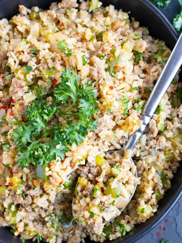 One of the best cauliflower rice recipes that is low-carb and keto in a black bowl with a spoon.