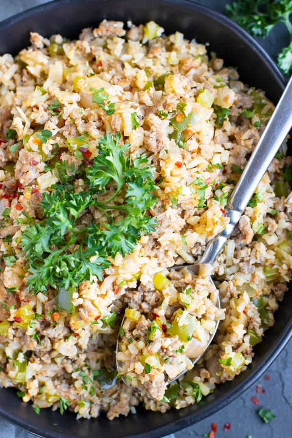 One of the best cauliflower rice recipes that is low-carb and keto in a black bowl with a spoon.