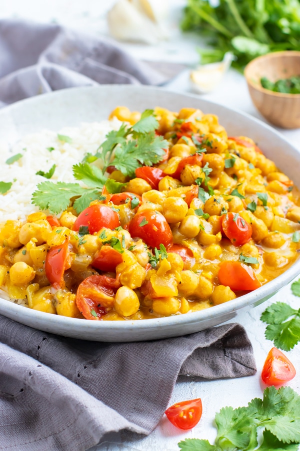 A healthy and easy chickpea curry recipe served in a white bowl on a white table.