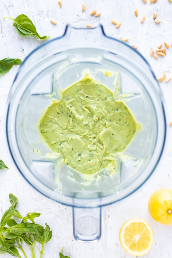 A blended up avocado pesto sauce in a Vitamix bowl.