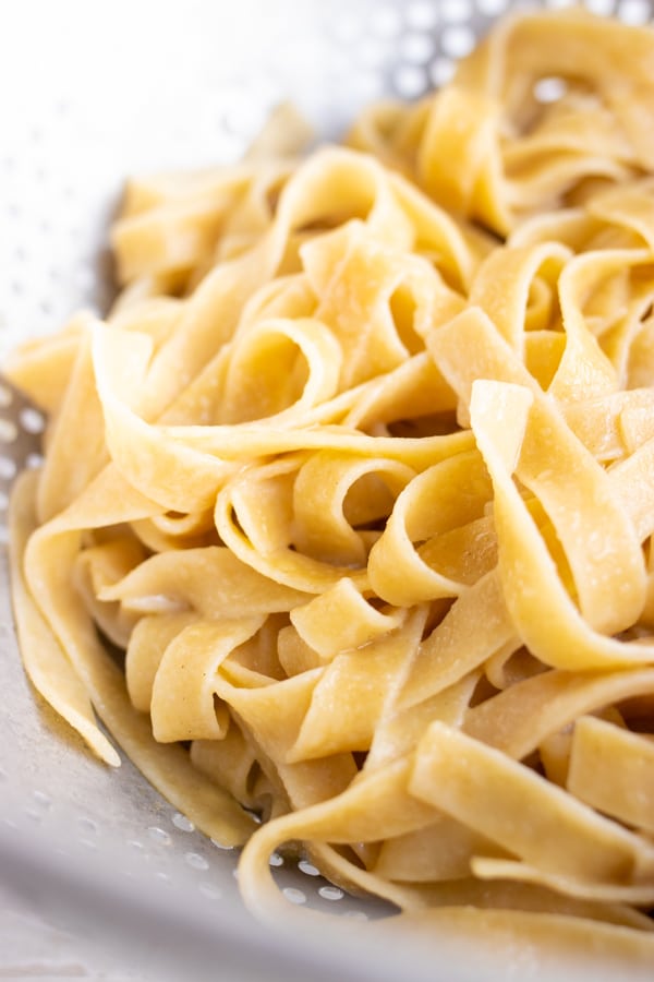 Vegan tagliatelle pasta in a colander.