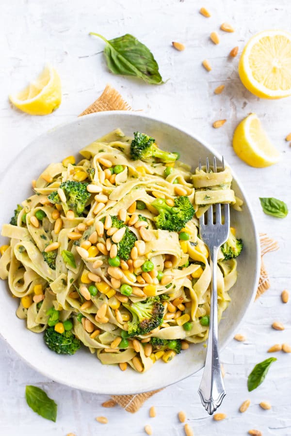 A single serving of avocado pasta with basil, lemons, and broccoli.