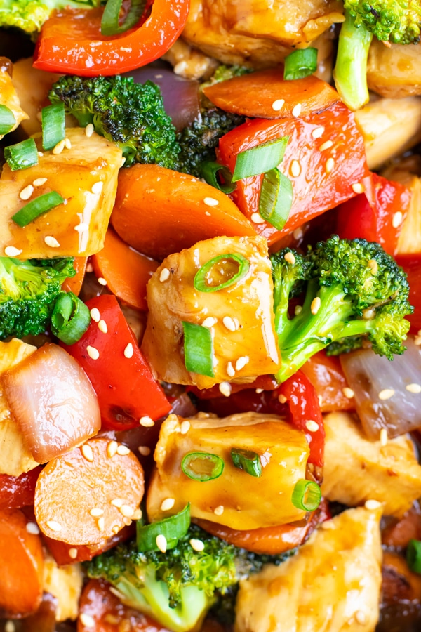 Teriyaki chicken stir-fry with red bell pepper, carrots, broccoli, and red onion.