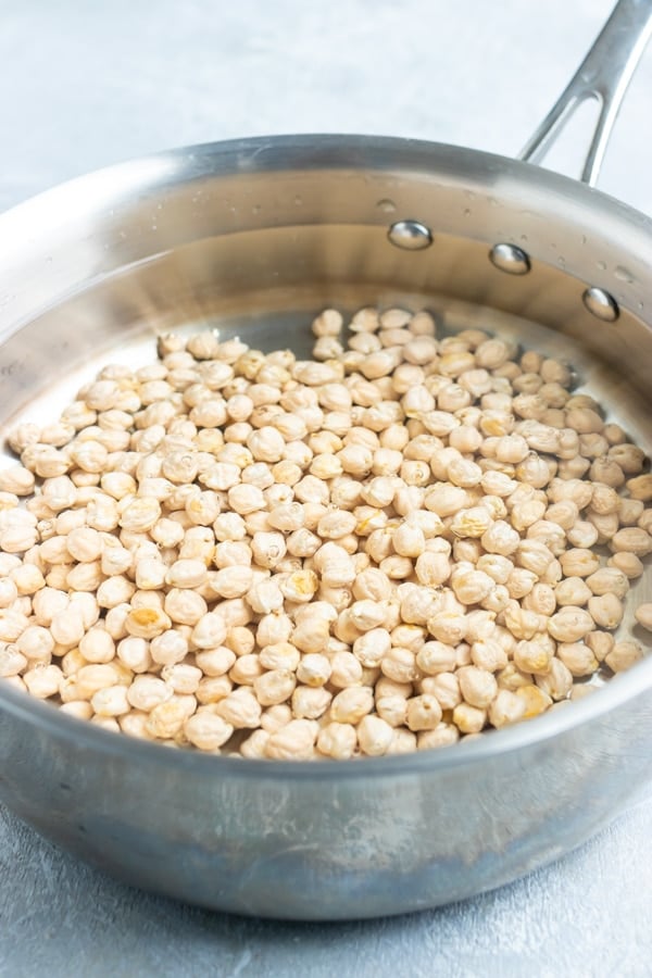 Dried chickpeas in a pot with water.