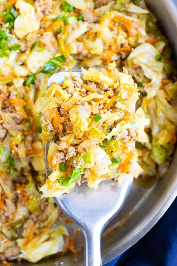 A skillet full of a ground turkey and cabbage recipe for egg roll in a bowl.