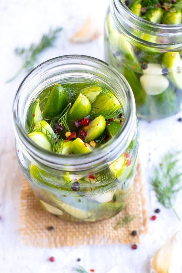 Quick pickles in a sweet and sour vinegar and sugar solution with fresh dill, red pepper flakes, and garlic cloves.